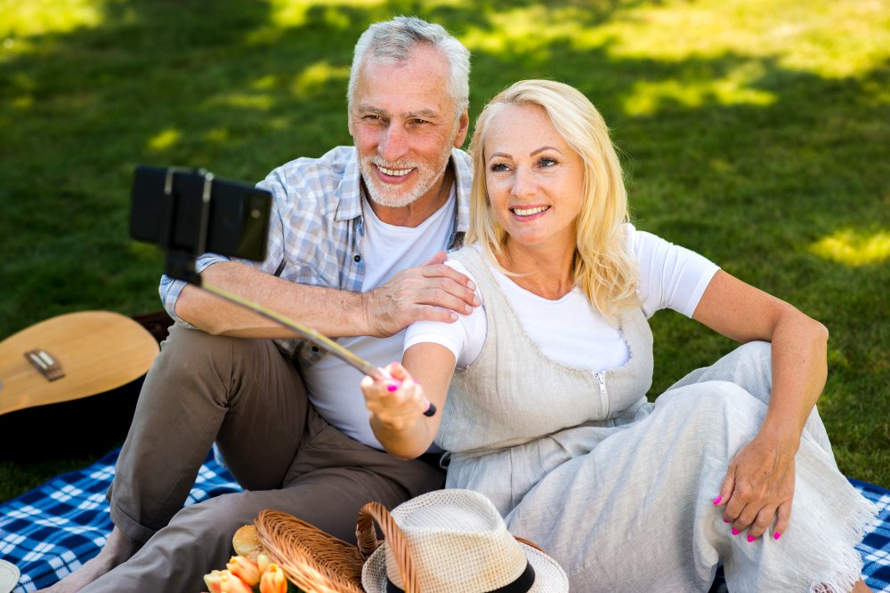 Ein Paar über 50 macht bei einem Picknick ein gemeinsames Foto